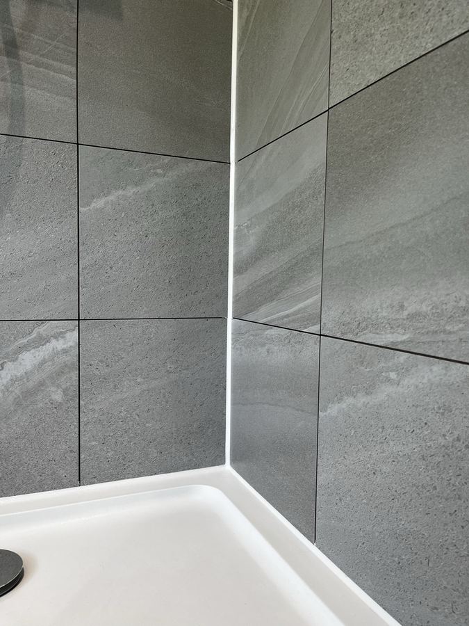 Shower enclosure sanitary sealant replacement in Harrogate - failed, mouldy silicone removed and replaced with mould-resistant sanitary-grade product.