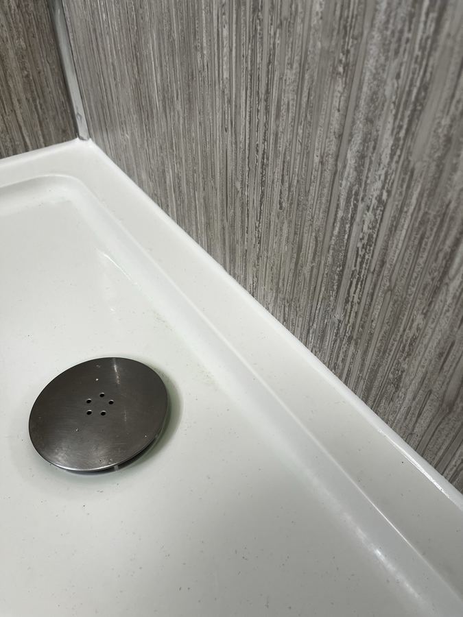 Shower tray sanitary sealant replacement in Baildon - failed perimeter silicone replaced after mould growth.