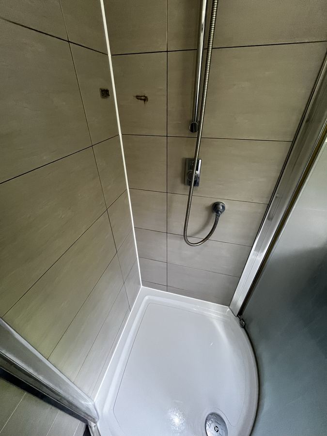 Shower cubicle sanitary sealant replacement in Harrogate - failed and mould-affected silicone fully replaced.