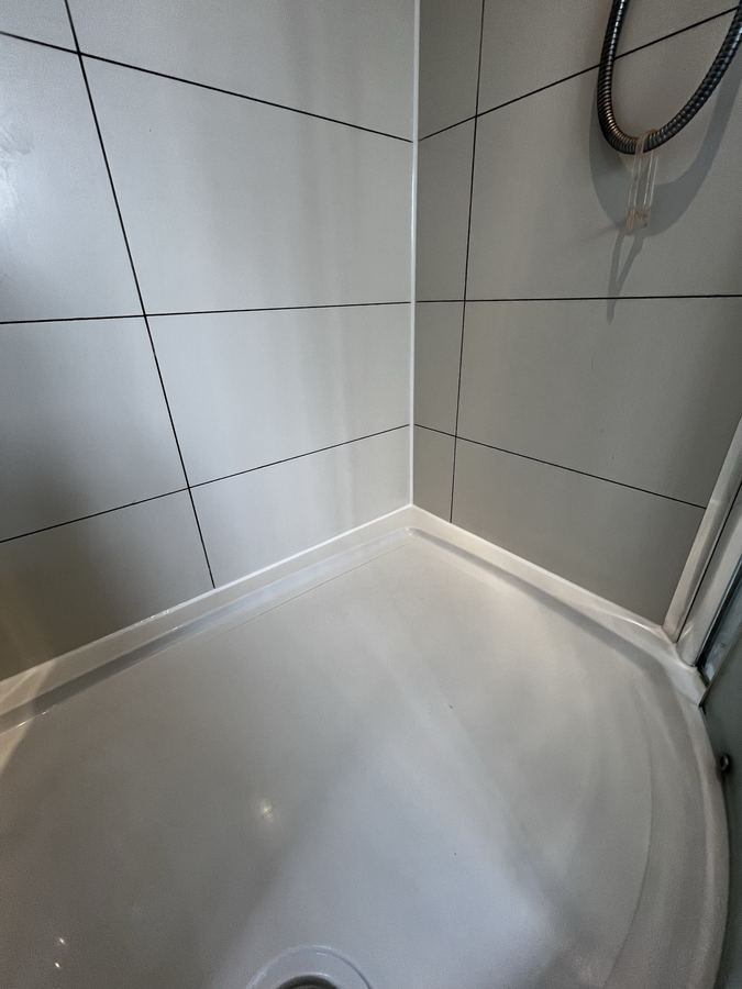 Shower tray perimeter resealing in Harrogate - mould-resistant sanitary sealant applied to a fully cleaned substrate.